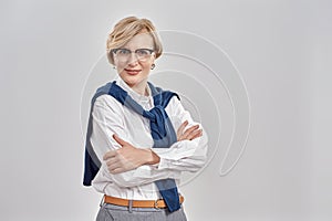 Portrait of elegant middle aged caucasian woman wearing business attire and glasses looking at camera while posing