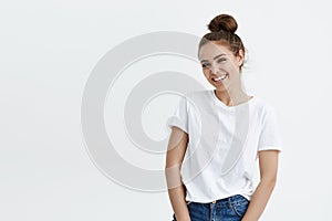 Portrait of elegant modern european woman with bun hairstyle smiling broadly at camera, expressing excitement while