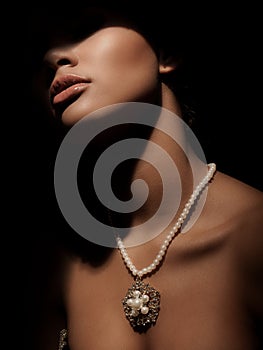 Portrait of an elegant and mystery smart lady with luxury jewelry made from precious metals on her neck