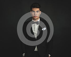 portrait of elegant young man in black tuxedo