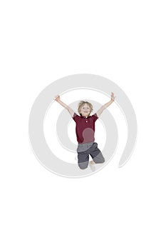 Portrait of elementary boy jumping in air with arms raised over white background