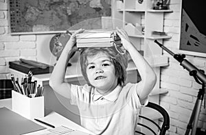 Portrait of elementary pupil looking at camera. Happy cute clever boy with book. Little student boy happy with an