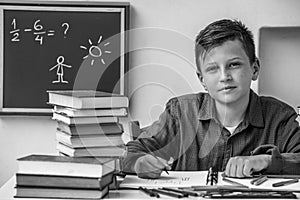 Portrait of elementary school student doing homework. Black and white photo.