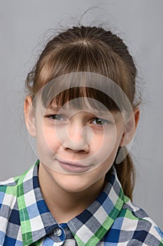 Portrait of embarrassed ten-year-old girl, European appearance, close-up