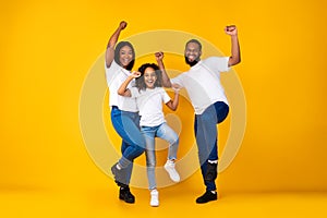 Portrait of emotional black family dancing at studio