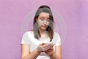 Portrait of emotional surprise and shocked girl looking at phone