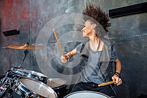 Portrait of emotional woman playing drums in studio