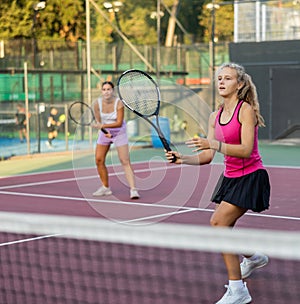 Portrait of emotional woman tennis player during friendly doubles couple match with woman partner
