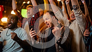 Portrait of a Emotional Young Man Holding a Smartphone, Happy About the Sports Bet on a Soccer Match