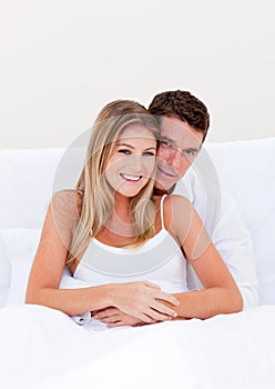 Portrait of an enamored couple sitting on bed