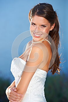 Portrait of and enchanting wife-to-be. Portrait of a beautiful young bride looking over her shoulder and smiling at the