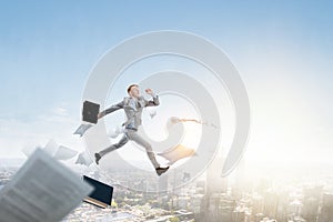 Portrait of energetic businessman jumping in open air