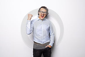 Portrait of a energetic young business man enjoying success, screaming against white background