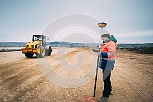 Portrait of engineer on construction site, surveyor using gps system and theodolite on highway construction site