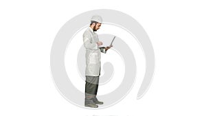 Portrait of an engineer in helmet using a laptop on white background.