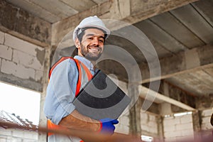 Portrait of an engineer inspecting a building smile for the camera at the construction site