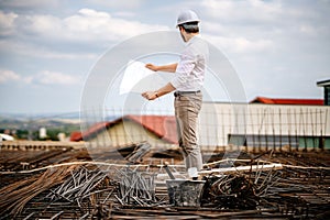 Portrait of engineer looking at paper plans, construction blueprints