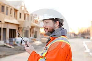 Portrait of engineer talking by walkie talkie on construction site.