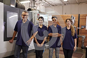Portrait Of Engineer Training Apprentices On CNC Machine