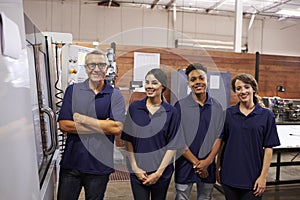Portrait Of Engineer Training Apprentices On CNC Machine