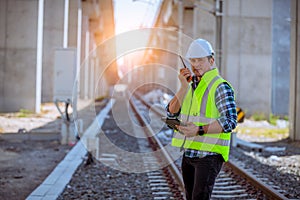 Portrait engineer under inspection and checking construction process railway and checking work on railroad station .Engineer weari