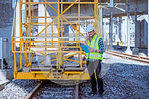 Portrait engineer under inspection and checking construction process railway and checking work on railroad station .Engineer weari