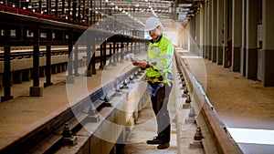 Portrait engineer under inspection and checking construction process railway and checking work on railroad station .Engineer weari