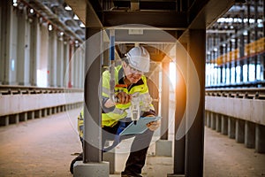 Portrait engineer under inspection and checking construction process railway and checking work on railroad station .Engineer weari