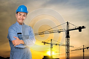 Portrait of engineer wear blue helmet safty on construction site with crane background silhouette