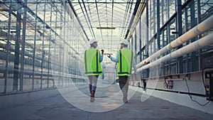 Portrait engineers walking in factory checking safety discussing production