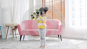 Portrait of enjoy happy kids using VR metaverse gaming technology in living room at home. Child smiling and having fun using