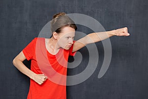 Portrait of enraged dissatisfied girl holding fists clenched