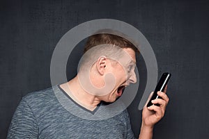 Portrait of enraged man shouting at somebody via phone