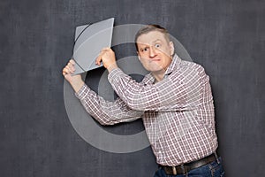 Portrait of enraged man swinging folder trying to hit someone