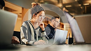 Portrait of Enthusiastic Hispanic Young Woman Working on Computer in a Modern Bright Office