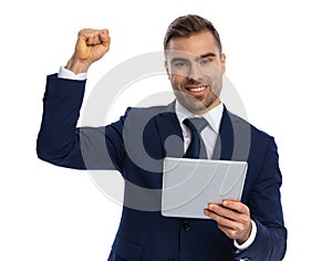 portrait of enthusiastic man holding fist in the air and smiling