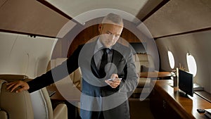 Portrait of entrepreneur with phone inside of expensive business jet.