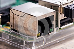 A portrait of a ethernet network port on a pcb or circuit board. The gate is ready to plug a cable in to setup a network or