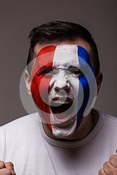 Portrait Euphoric scream of France football fan in win game of France national team on grey background.