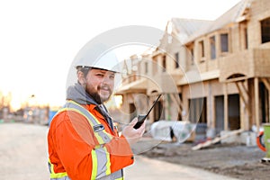 Portrait of european engineer talking by walkie talkie on construction site.