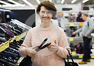 Portrait of a European woman choosing an electric styler