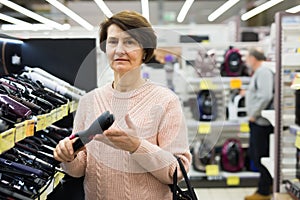 Portrait of a European woman choosing an electric styler