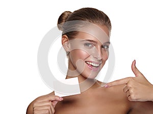 Portrait of an european young smiling girl with healthy perfect smooth skin, who is holding a business visiting card