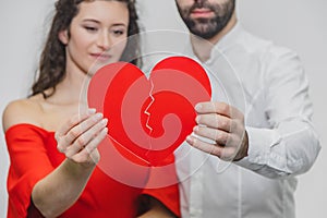 Portrait of an Excessive Couple. Hold two pieces of cardboard. Women dressed in red men`s dresses in a white shirt.