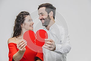 Portrait of an Excessive Couple. Hold two pieces of cardboard. Women dressed in red men`s dresses in a white shirt.