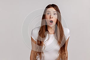 Portrait of excited amazed woman looking with mouth open in surprise, shocked facial expression.