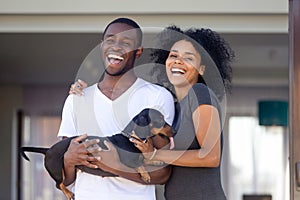 Portrait of excited black family posing with dog near home