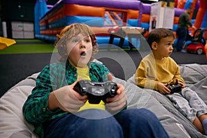 Portrait of excited boy with surprise and joy on face playing video game