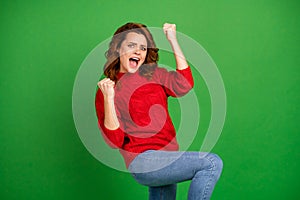 Portrait of excited cheerful delighted girl win competition raise fist scream yeah wear jumper isolated over vibrant