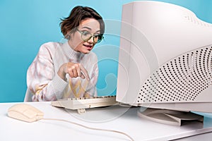 Portrait of excited corporate workaholic girl finger press typing keyboard old pc screen workplace isolated on blue